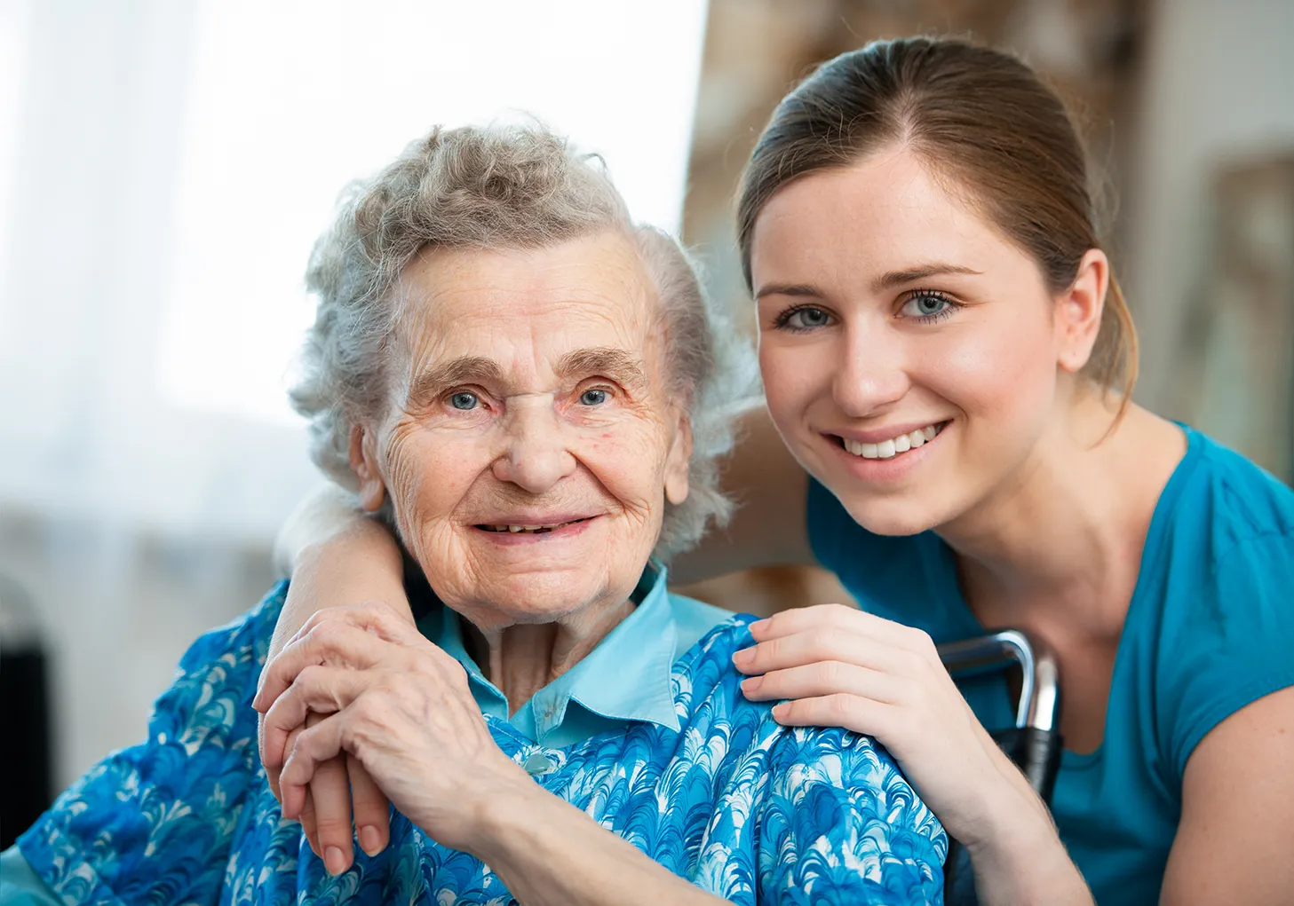 elderly woman with younger person looking at camera