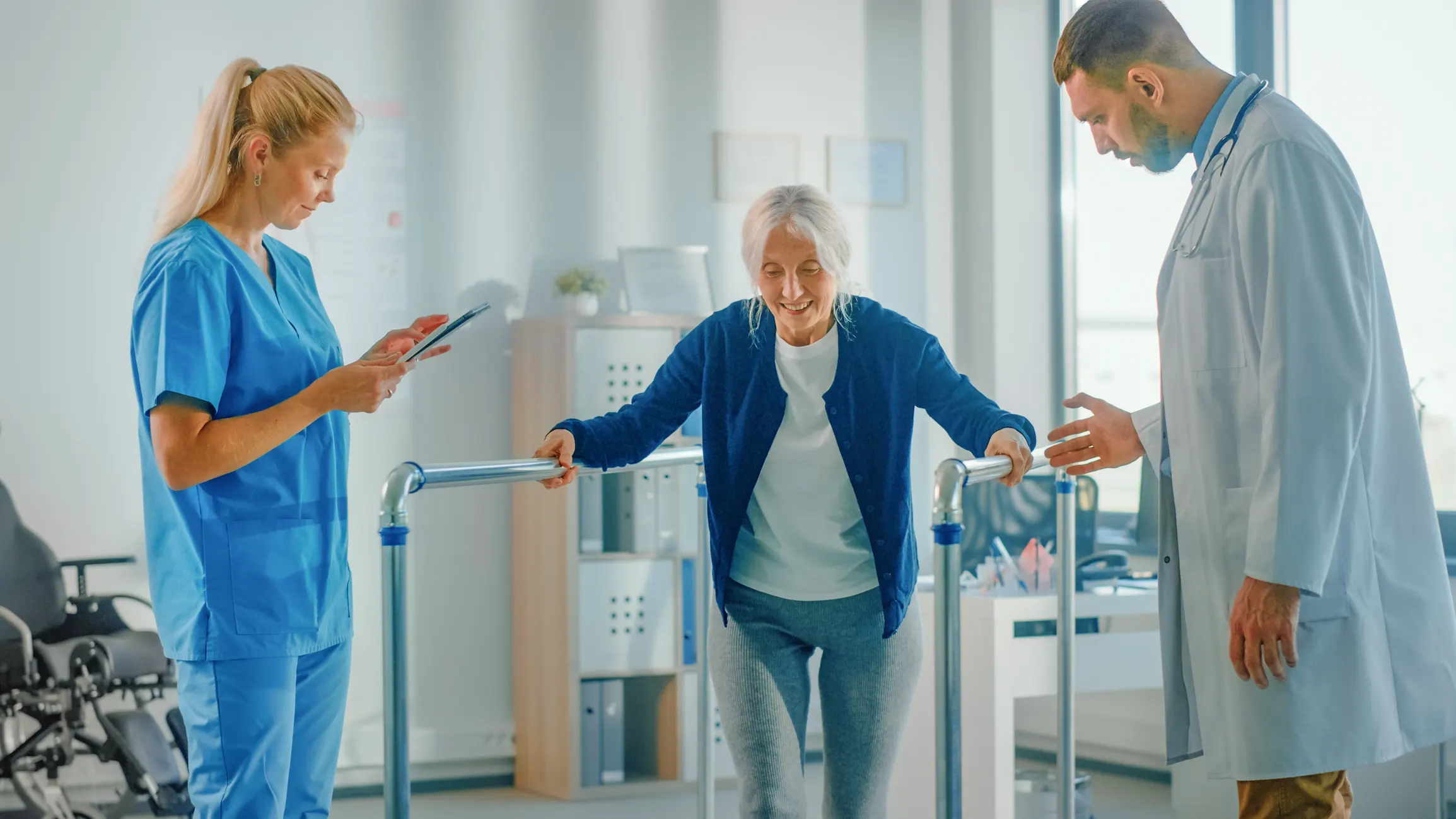 Physical therapist helping patient walk with parallel bars